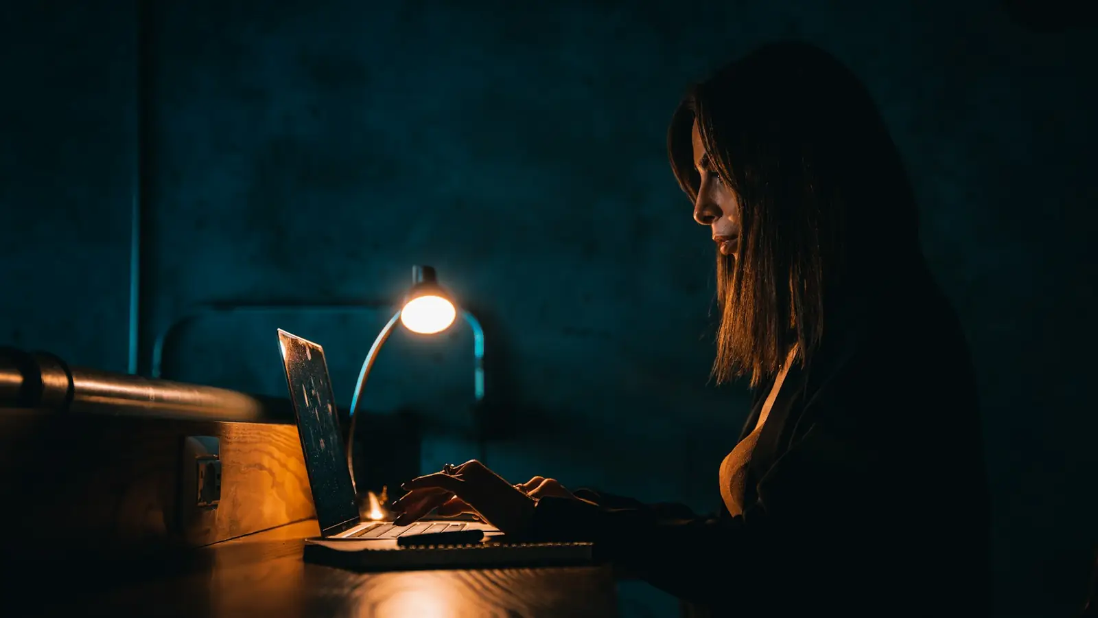 Profissional trabalhando à noite sob a luz de uma luminária